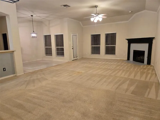 a view of an empty room with a fireplace and a window