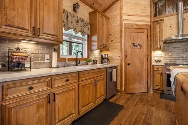 a kitchen with stainless steel appliances granite countertop a refrigerator a sink dishwasher and cabinets with wooden floor