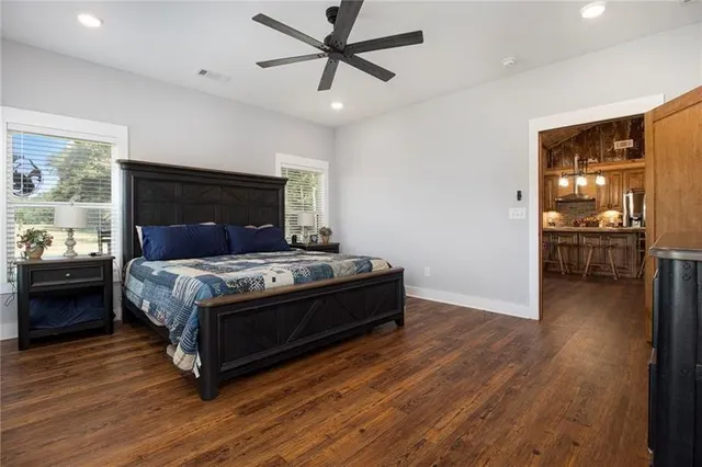 a bed sitting in a spacious bedroom next to a window