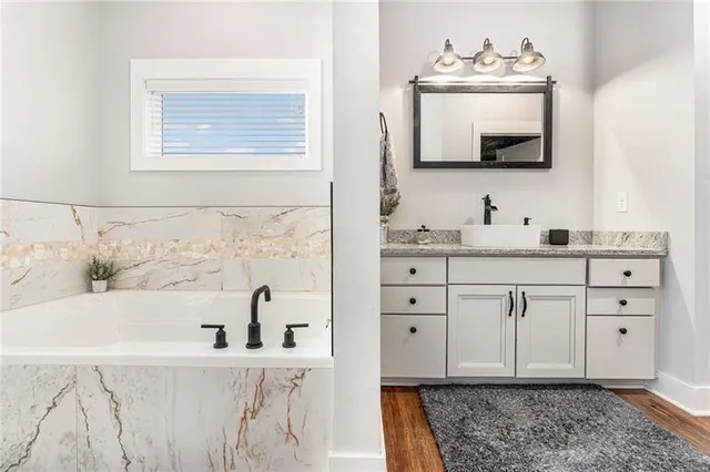 a bathroom with a bathtub sink and mirror