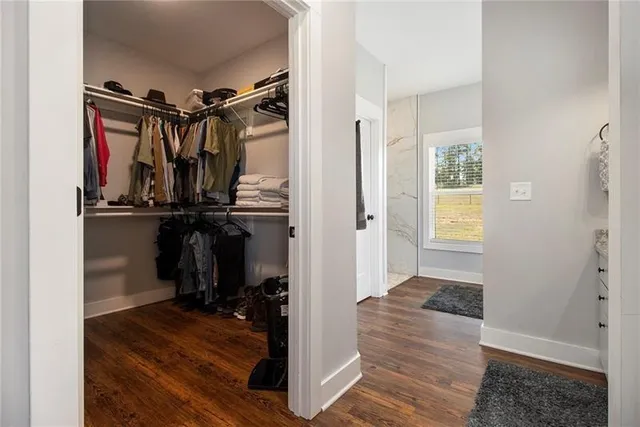 a view of a hallway with wooden floor and closet