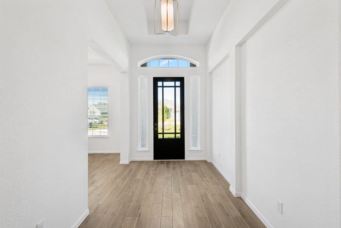 5033 Bluebell Way Waller, TX 77484 - Photo 3 of 23 a view of a hallway with wooden floor and a chandelier