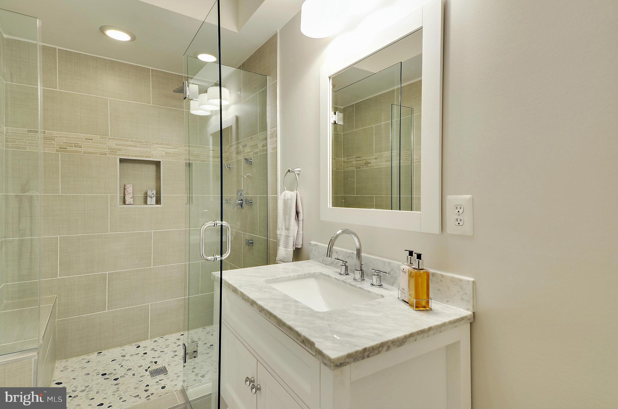 1350 K Street Southeast Washington, DC 20003 - Photo 15 of 28 a bathroom with a granite countertop sink a shower and a mirror