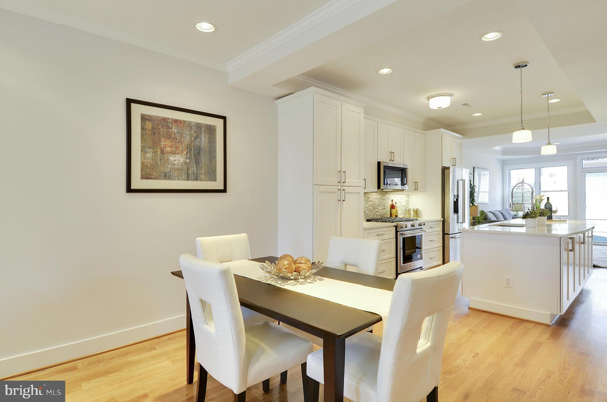 1350 K Street Southeast Washington, DC 20003 - Photo 6 of 28 a kitchen with stainless steel appliances kitchen island granite countertop a refrigerator a stove and white cabinets with wooden floor