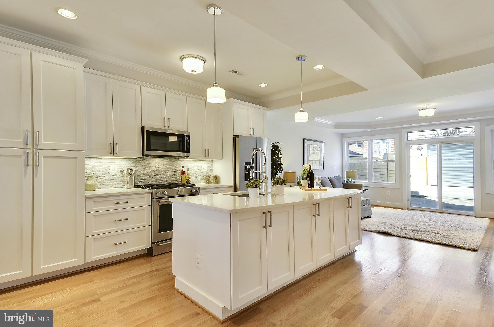 1350 K Street Southeast Washington, DC 20003 - Photo 7 of 28 a large white kitchen with lots of counter space a sink appliances and cabinets