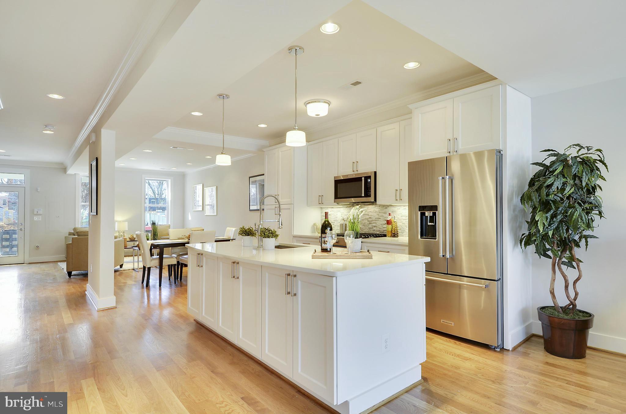1350 K Street Southeast Washington, DC 20003 - Photo 8 of 28 a kitchen with stainless steel appliances granite countertop a refrigerator a stove a sink and a dining table with wooden floor