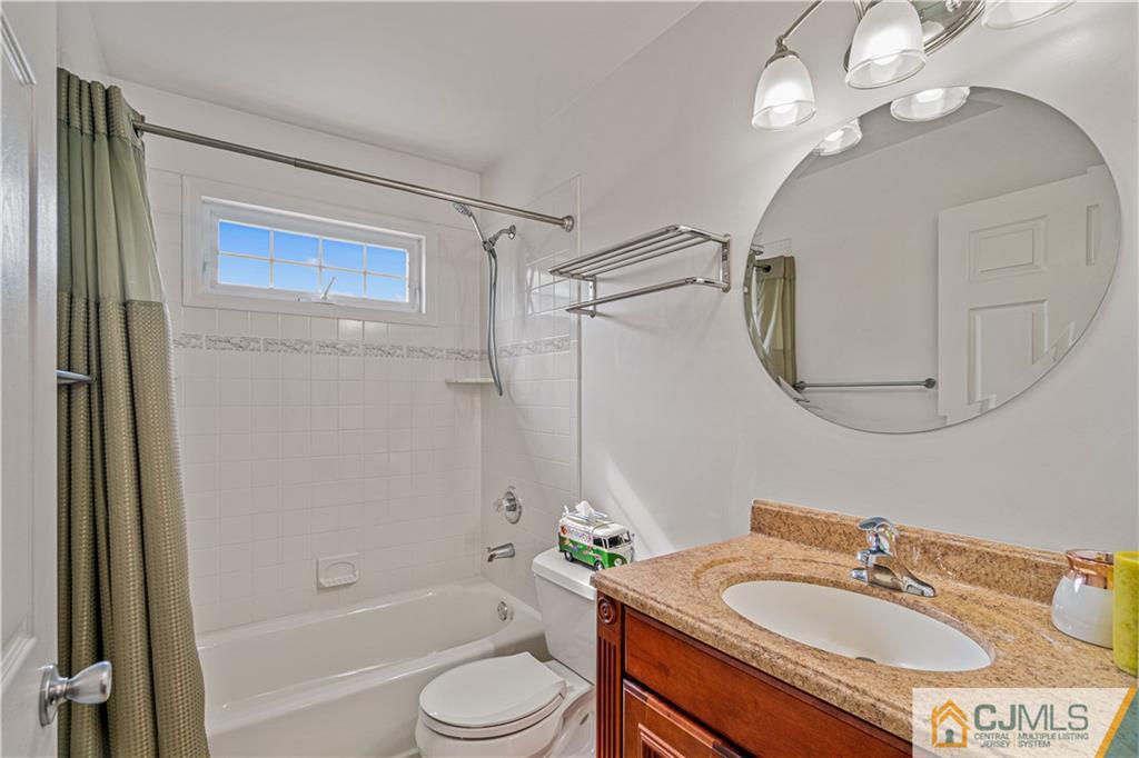 18 Main Street Helmetta, NJ 08828 - Photo 22 of 32 a bathroom with a granite countertop sink a toilet a mirror a bathtub and shower
