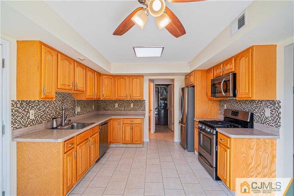 18 Main Street Helmetta, NJ 08828 - Photo 8 of 32 a kitchen with stainless steel appliances granite countertop a stove a sink and a refrigerator