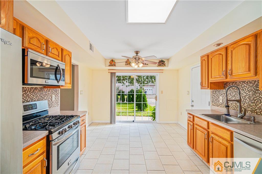 18 Main Street Helmetta, NJ 08828 - Photo 9 of 32 a kitchen with stainless steel appliances a stove a sink and a microwave
