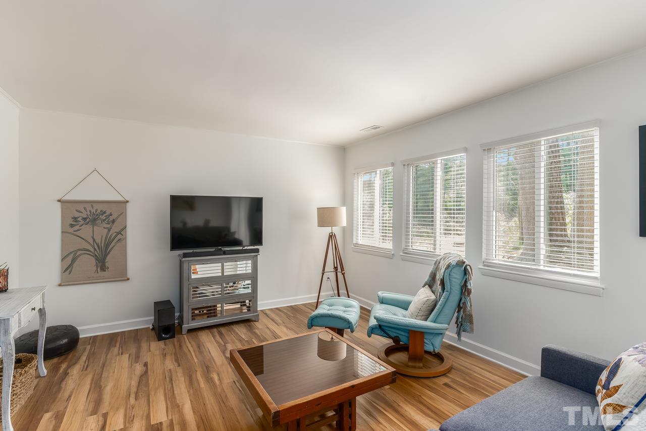 728 Godwin Court Raleigh, NC 27606 - Photo 5 of 25 a living room with furniture a flat screen tv and a large window