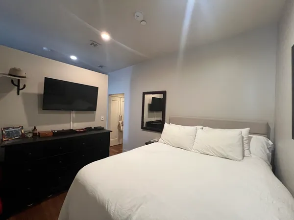 a bedroom with a bed and a flat screen tv