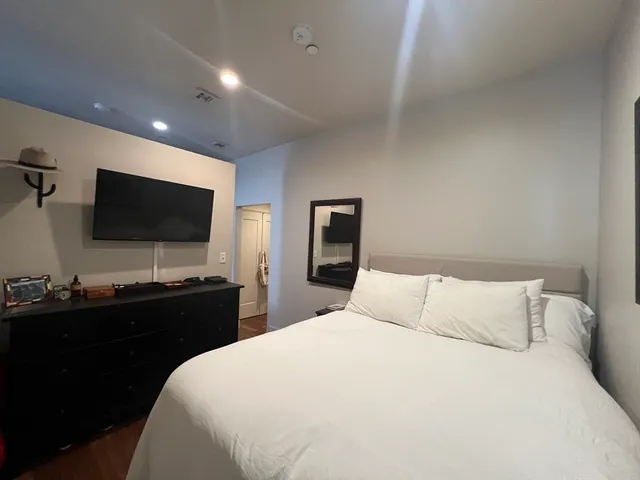 a bedroom with a bed and a flat screen tv