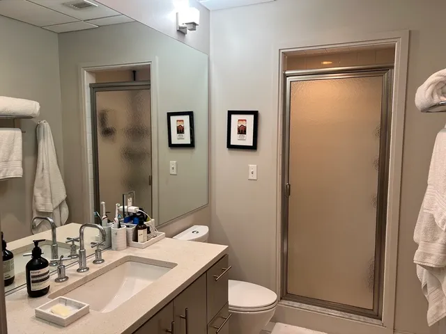 a bathroom with a granite countertop sink toilet and shower