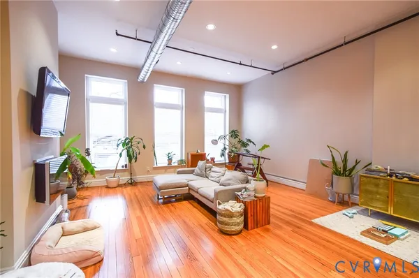 a living room with furniture wooden floor and a potted plant
