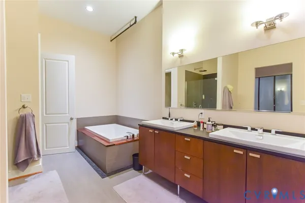a bathroom with a double vanity sink tub and a mirror