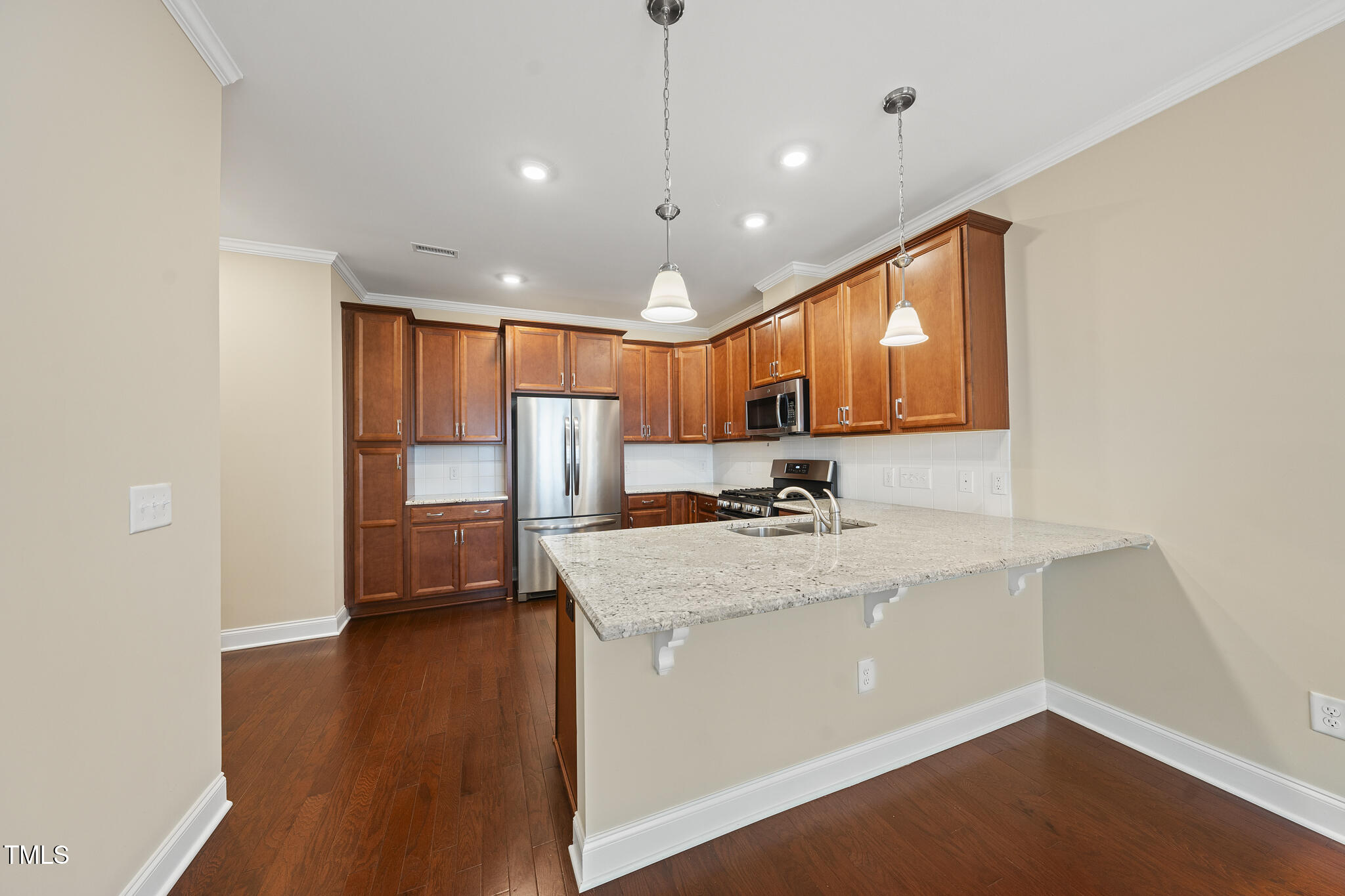 111 Wards Ridge Drive Cary, NC 27513 - Photo 8 of 46 a kitchen with stainless steel appliances granite countertop a sink refrigerator and wooden floor