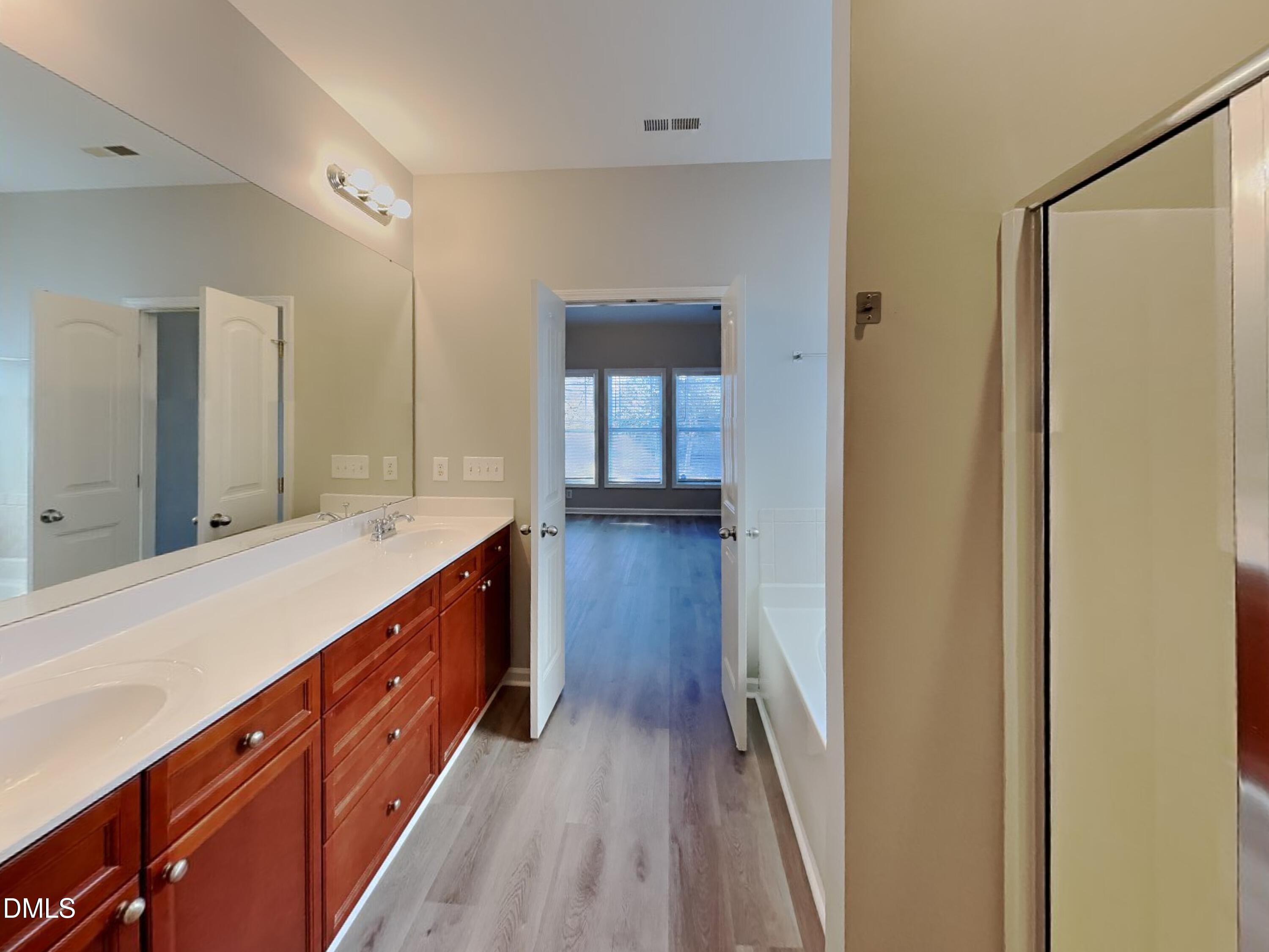 3152 Landing Falls Lane Raleigh, NC 27616 - Photo 12 of 24 a bathroom with a sink a mirror and a bathtub
