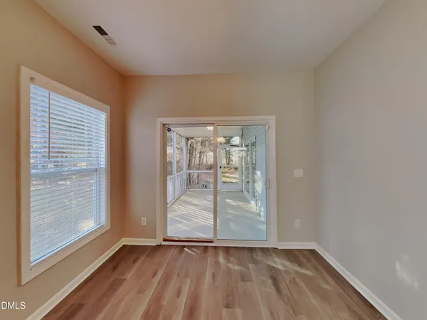an empty room with wooden floor and door