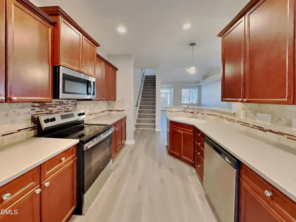 a kitchen with stainless steel appliances sink stove microwave and cabinets