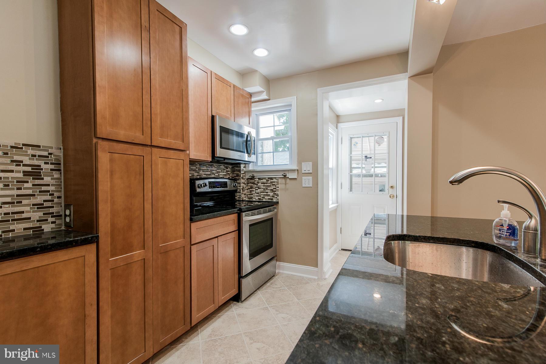34 Eastship Road Baltimore, MD 21222 - Photo 5 of 19 a kitchen with stainless steel appliances granite countertop a refrigerator a stove and a sink with wooden floor