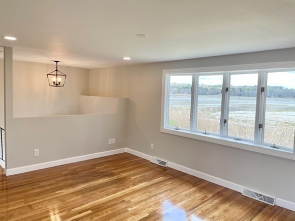 57 Marshview Drive Marshfield, MA 02050 - Photo 2 of 13 an empty room with wooden floor and windows