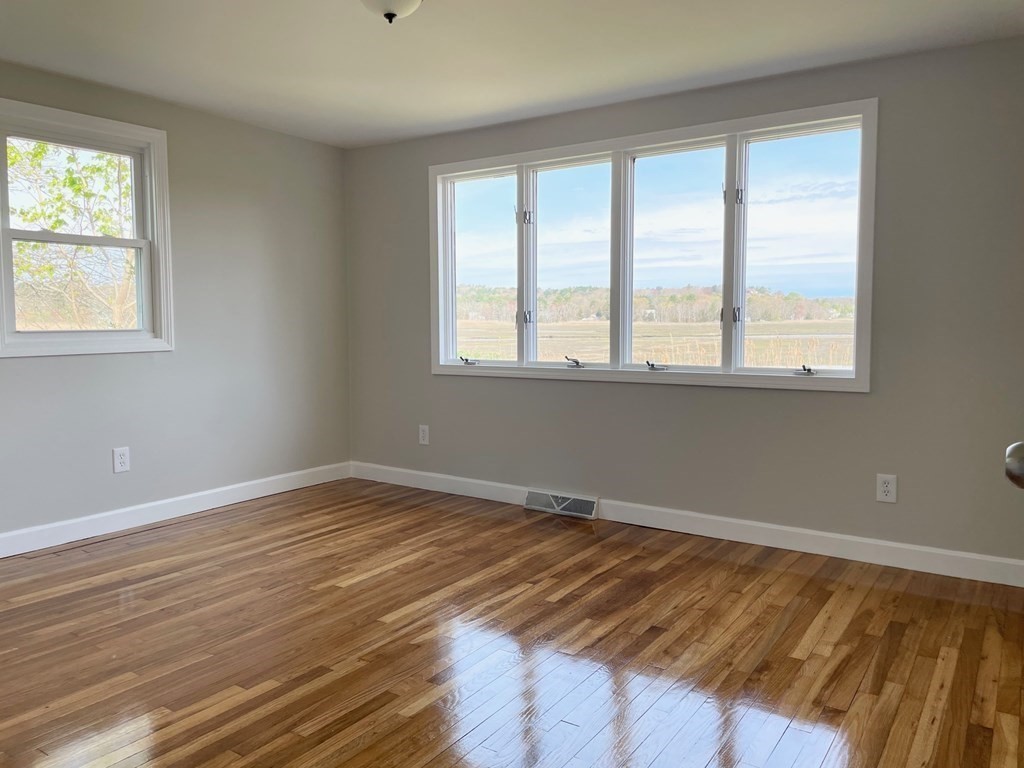57 Marshview Drive Marshfield, MA 02050 - Photo 6 of 13 a view of an empty room with wooden floor and a window