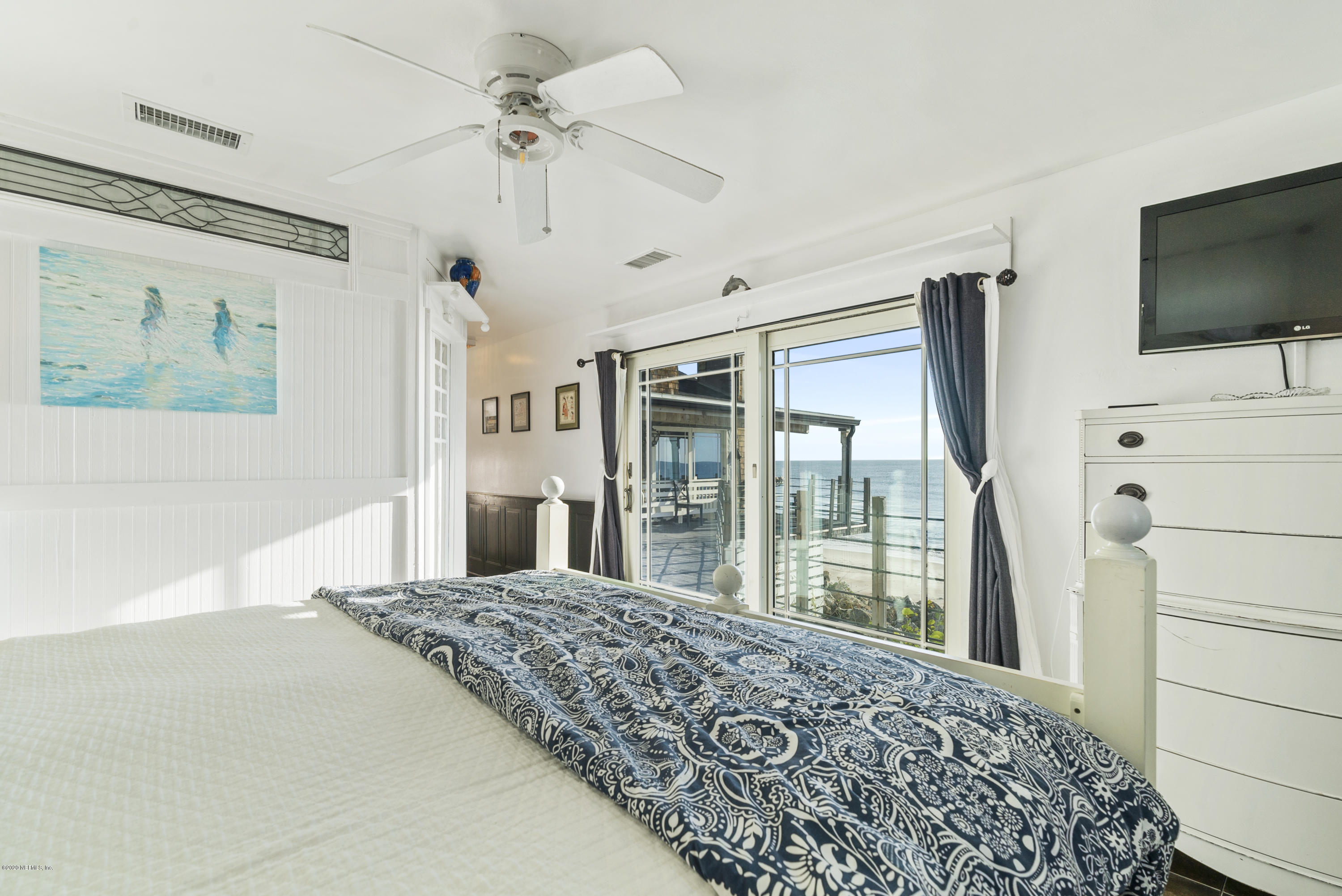 3490 Coastal Highway St. Augustine, FL 32084 - Photo 41 of 72 a bedroom with a large bed and a flat tv screen