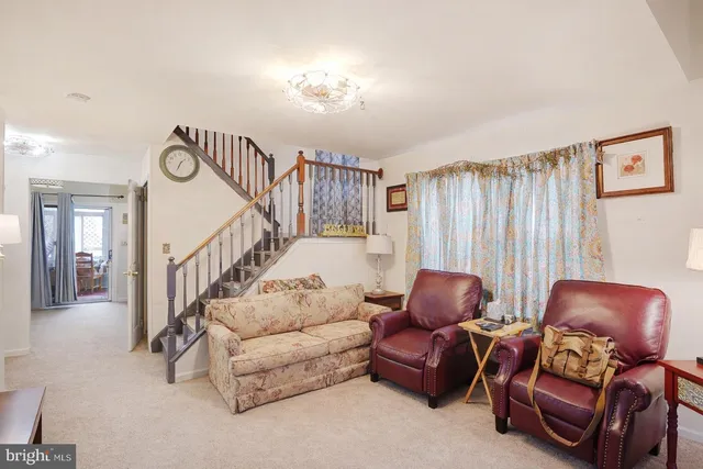 a living room with furniture a rug and a wall painting