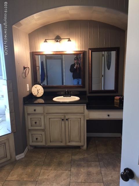 7303 Rochester Drive Amarillo, TX 79118 - Photo 13 of 20 a bathroom with a sink a vanity and mirror