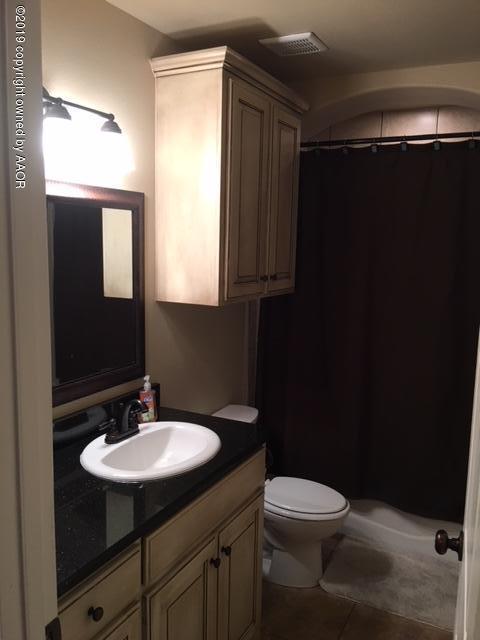 7303 Rochester Drive Amarillo, TX 79118 - Photo 16 of 20 a bathroom with a sink toilet a mirror and vanity