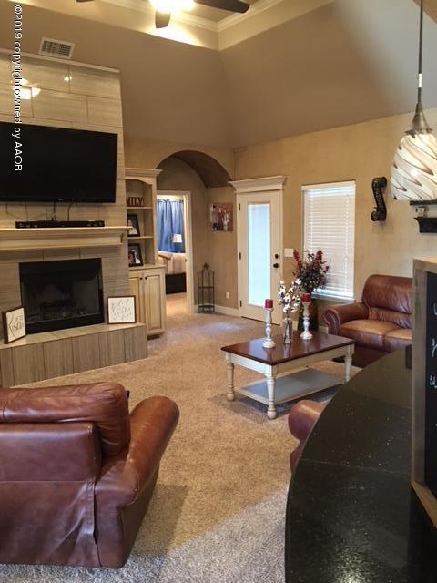 7303 Rochester Drive Amarillo, TX 79118 - Photo 4 of 20 a living room with furniture a flat screen tv and a fireplace