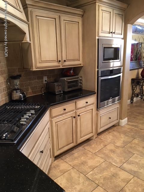 7303 Rochester Drive Amarillo, TX 79118 - Photo 8 of 20 a kitchen with stainless steel appliances granite countertop a stove and a microwave