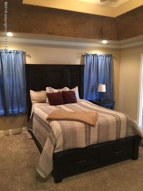 7303 Rochester Drive Amarillo, TX 79118 - Photo 9 of 20 a bedroom with a bed and a night stand