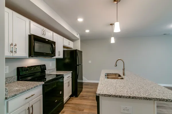 a kitchen with stainless steel appliances granite countertop a sink refrigerator and microwave