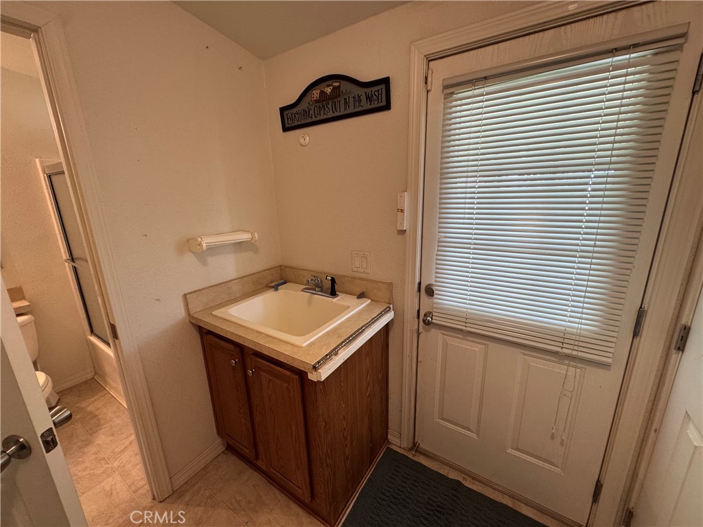 26362 Community Boulevard Barstow, CA 92311 - Photo 18 of 34 laundry room with and exit door and a door to the hall way bath
