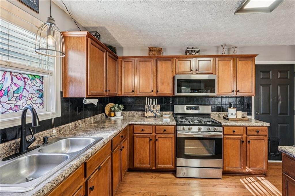 909 Elderberry Lane Villa Rica, GA 30180 - Photo 11 of 34 a kitchen with stainless steel appliances granite countertop a sink stove and microwave