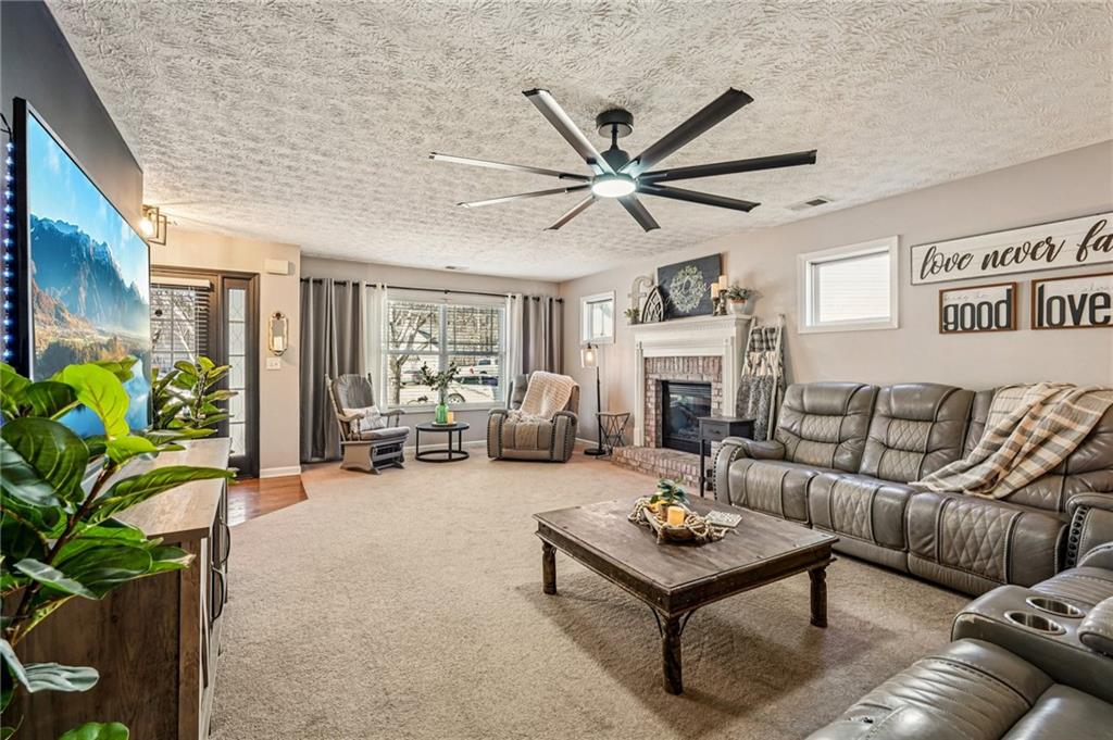909 Elderberry Lane Villa Rica, GA 30180 - Photo 2 of 34 a living room with furniture a fireplace and a potted plant