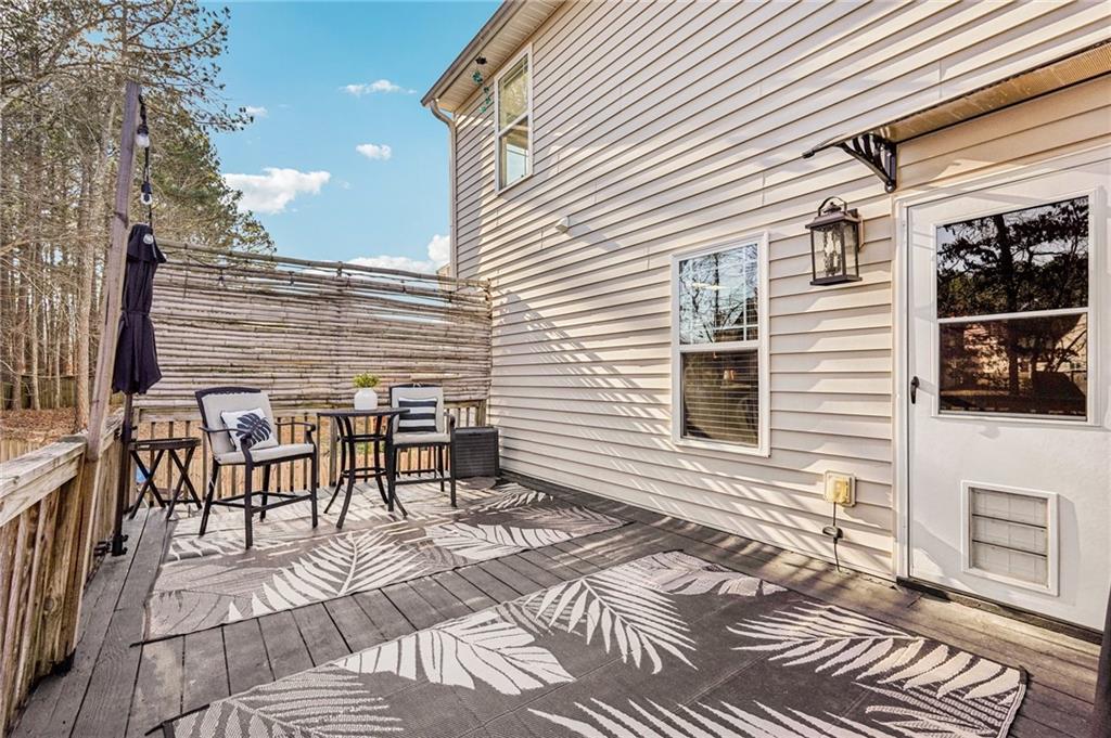 909 Elderberry Lane Villa Rica, GA 30180 - Photo 27 of 34 a view of a patio with table and chairs with wooden floor and fence