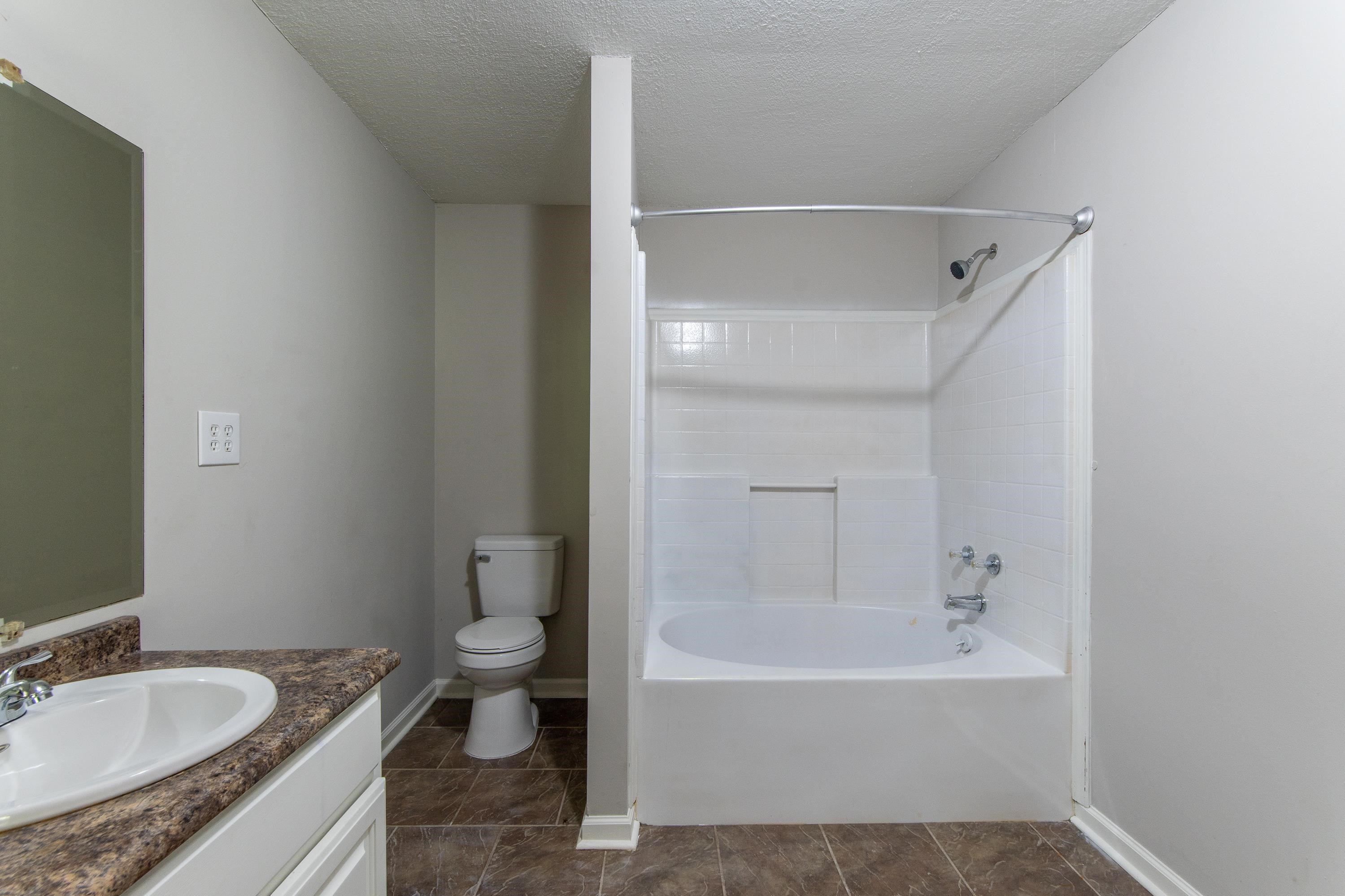 1020 County Road 600 Corinth, MS 38834 - Photo 12 of 37 a bathroom with a granite countertop sink a toilet and bathtub