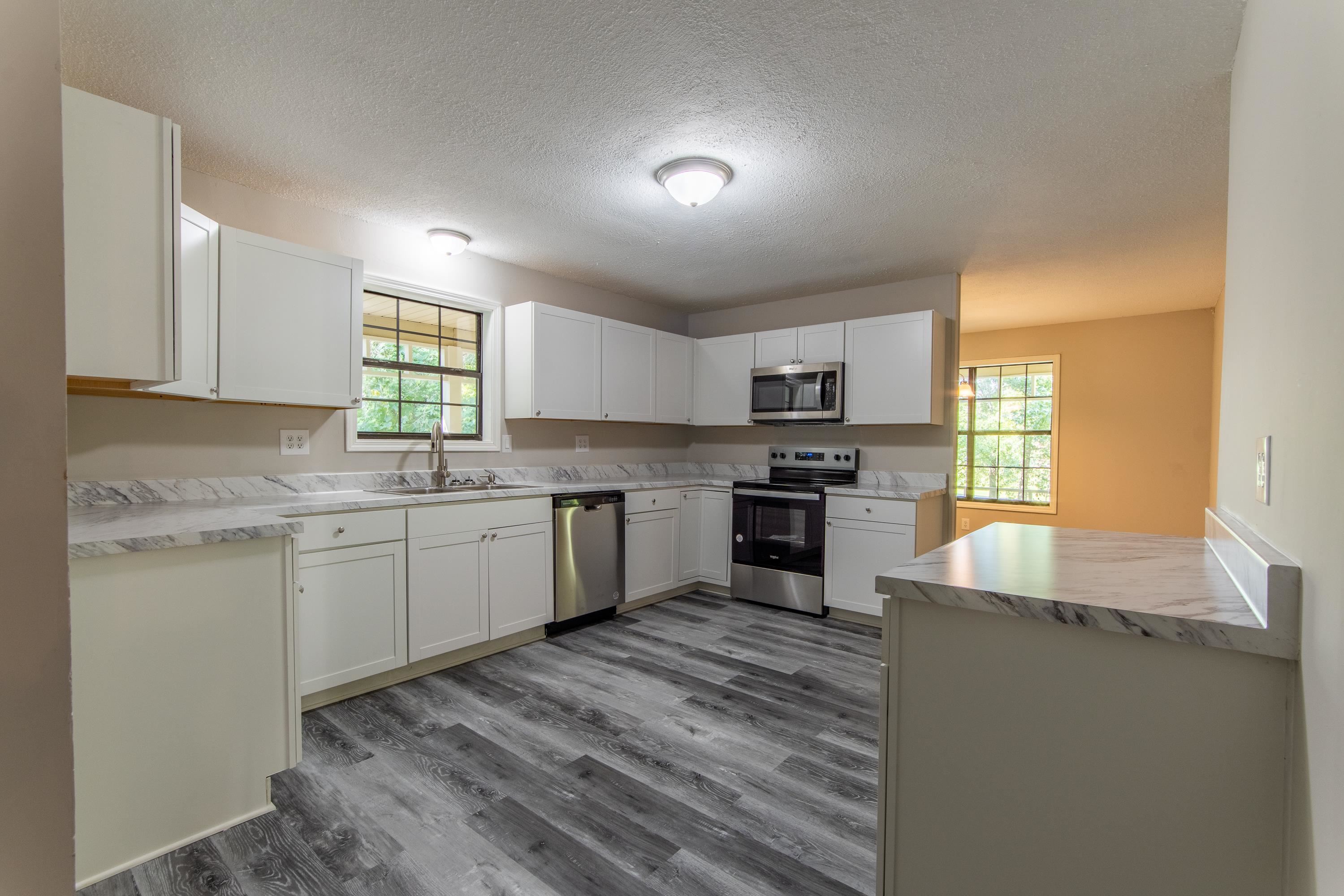 1020 County Road 600 Corinth, MS 38834 - Photo 19 of 37 a kitchen with granite countertop a sink cabinets stainless steel appliances and a window