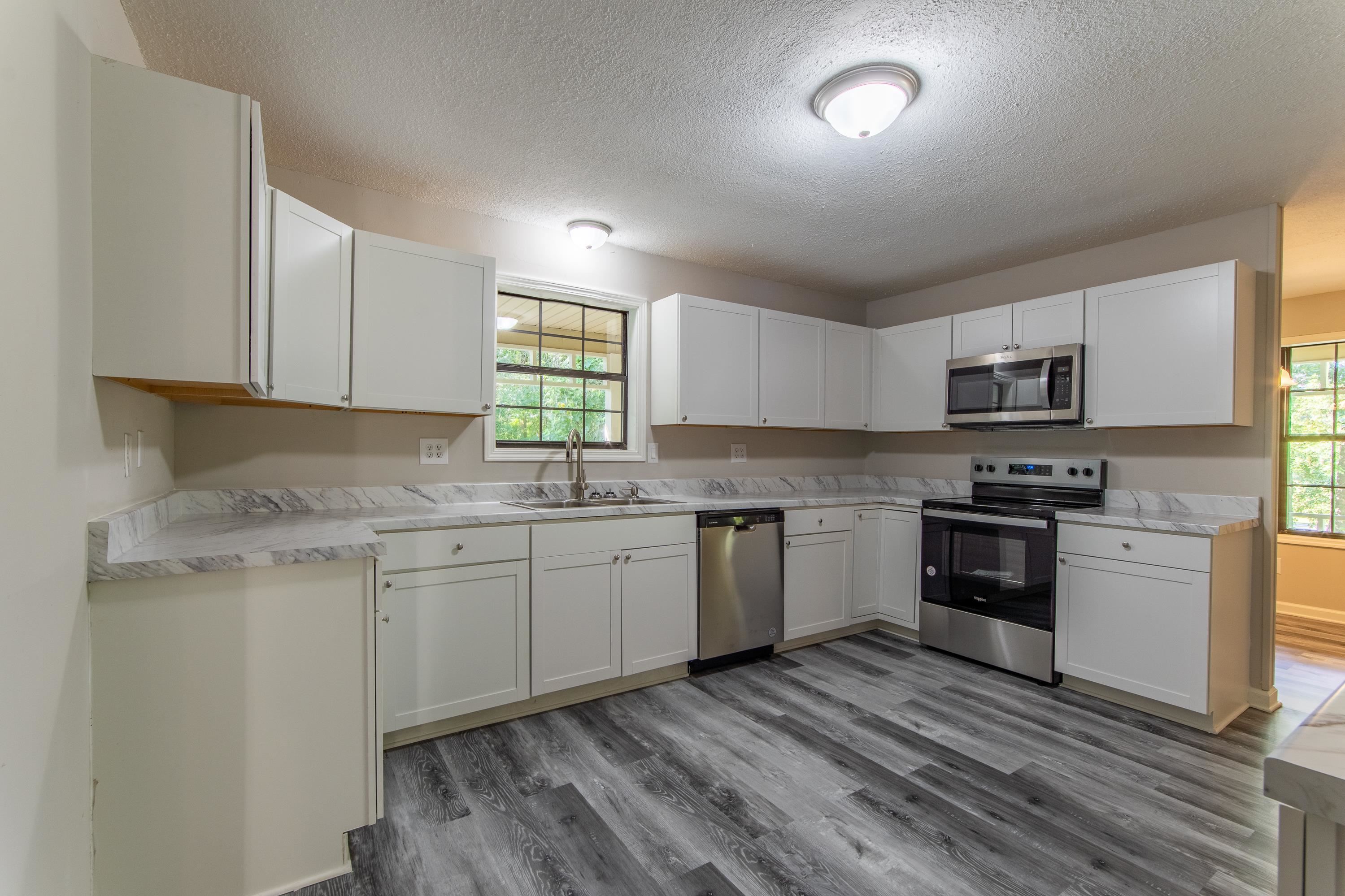 1020 County Road 600 Corinth, MS 38834 - Photo 20 of 37 a kitchen with granite countertop cabinets stainless steel appliances a sink and a window