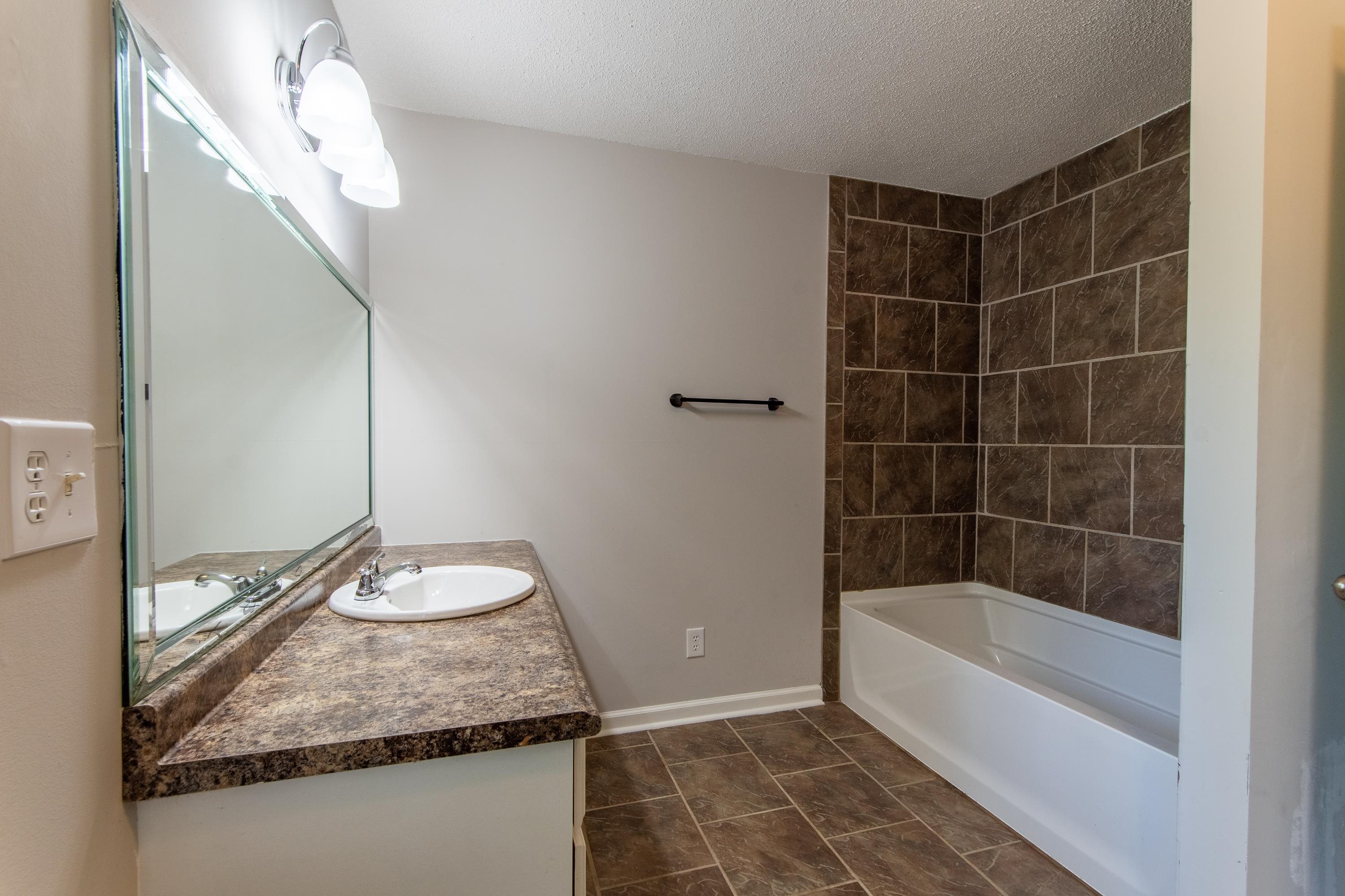 1020 County Road 600 Corinth, MS 38834 - Photo 29 of 37 a bathroom with a granite countertop sink and a mirror