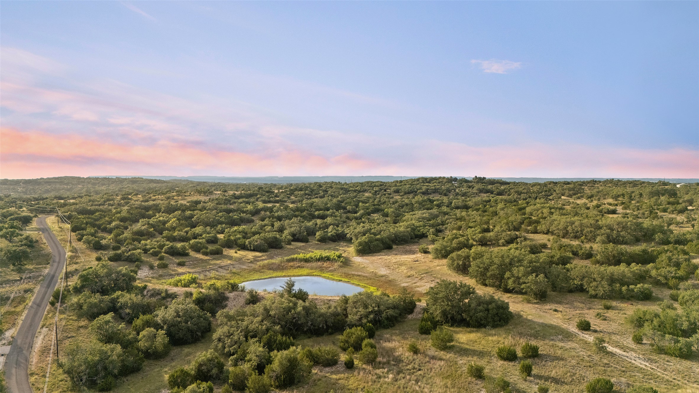 Lot 13 Byrd Ranch Road Johnson City, TX 78636 - Photo 1 of 19 Aerial view of property and surrounding area with a forest and a large body of water