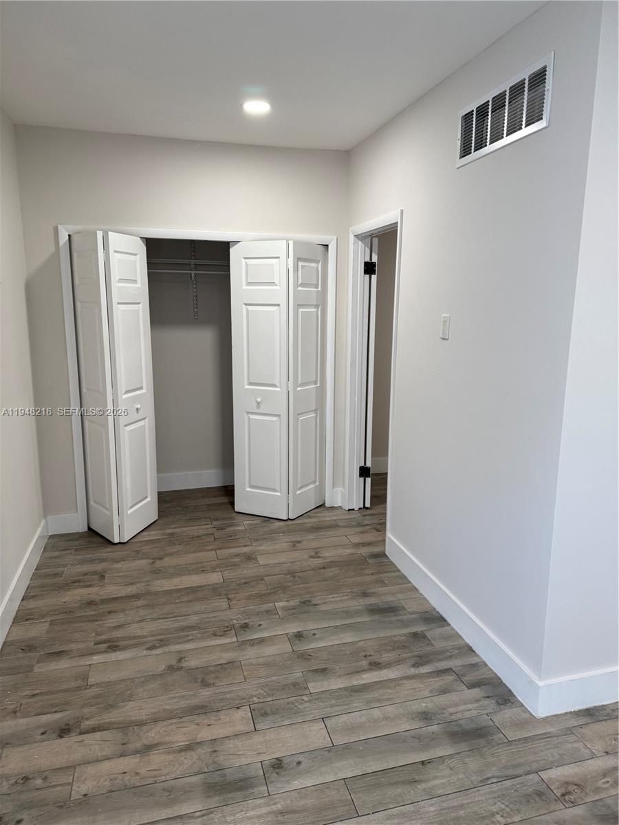 15740 Southwest 102nd Place Miami, FL 33157 - Photo 3 of 10 a view of an empty room with wooden floor and closet