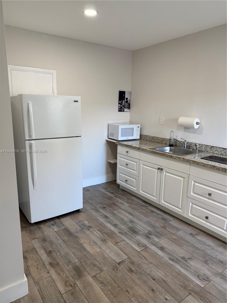 15740 Southwest 102nd Place Miami, FL 33157 - Photo 6 of 10 a kitchen with granite countertop white cabinets and white appliances