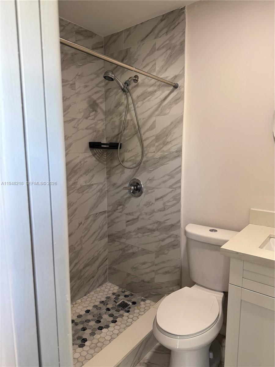 15740 Southwest 102nd Place Miami, FL 33157 - Photo 9 of 10 a white toilet sitting next to a shower curtain