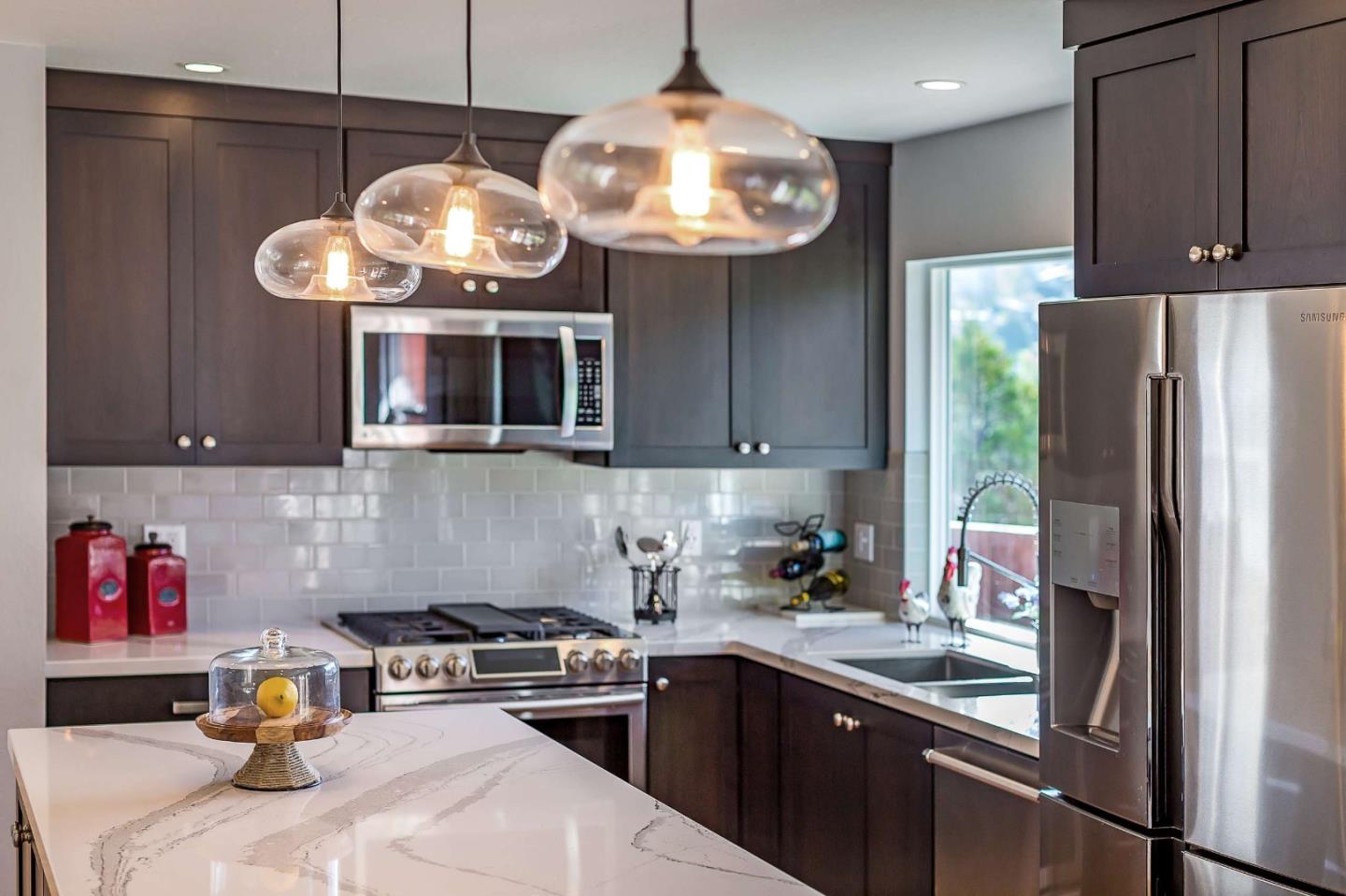 3 Yellowstone Way Pacifica, CA 94044 - Photo 9 of 21 a kitchen with stainless steel appliances granite countertop a sink a stove and a refrigerator with wooden cabinets
