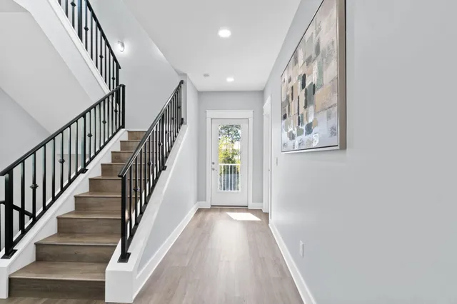 a view of hallway with wooden floor and stairs
