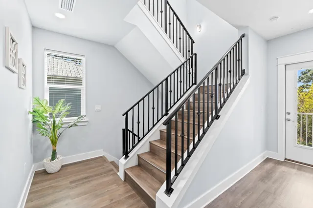 a view of staircase with wooden floor and a potted plant
