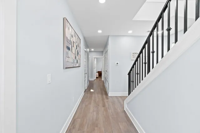 a view of a hallway with wooden floor and staircase